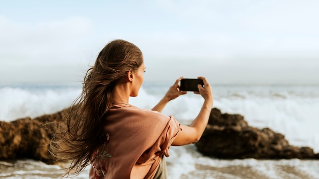 Foto gratuita mujer tomando fotos del mar