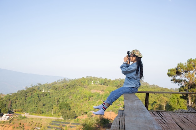 Mujer tomando fotos en medio de un bosque de naturaleza de árboles altos