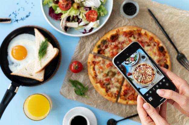 Mujer tomando fotos de pizza en rodajas