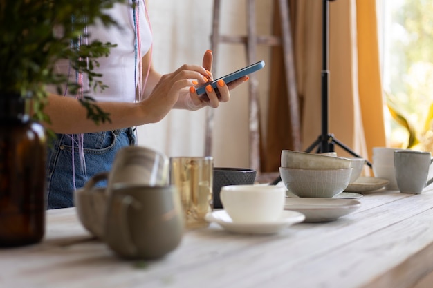 Mujer tomando fotos para su negocio con utensilios de cocina