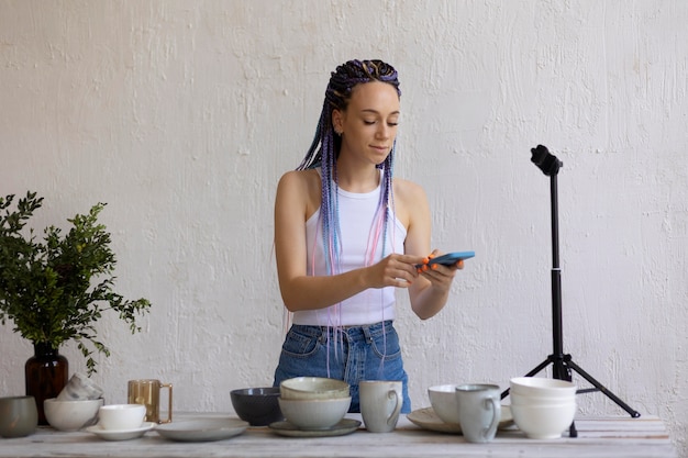 Mujer tomando fotos para su negocio con utensilios de cocina