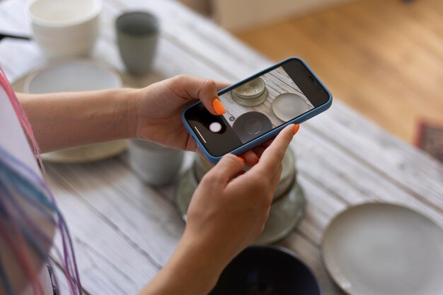 Mujer tomando fotos para su negocio con utensilios de cocina