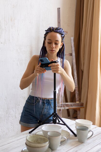 Mujer tomando fotos para su negocio con utensilios de cocina