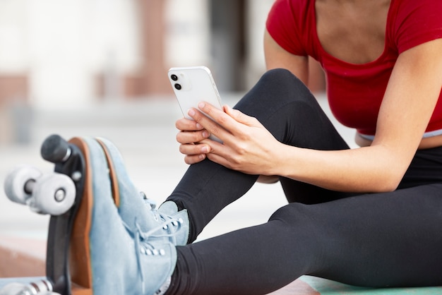 Mujer tomando fotos de sus patines al aire libre