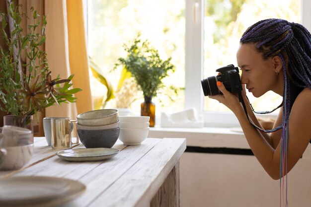 Mujer tomando fotos de utensilios de cocina de cerámica