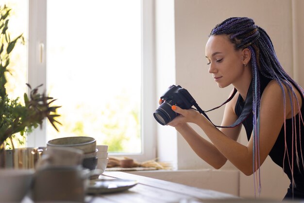 Mujer tomando fotos de utensilios de cocina de cerámica