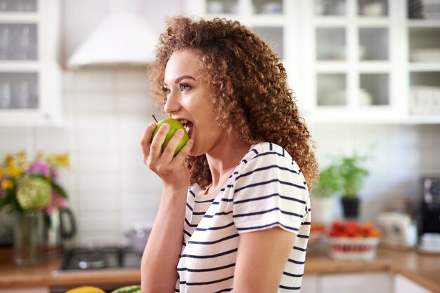 Mujer tomando un gran bocado de una manzana