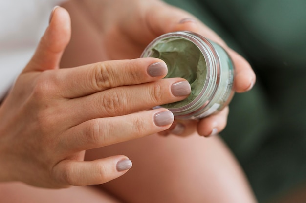 Mujer tomando mascarilla facial del contenedor