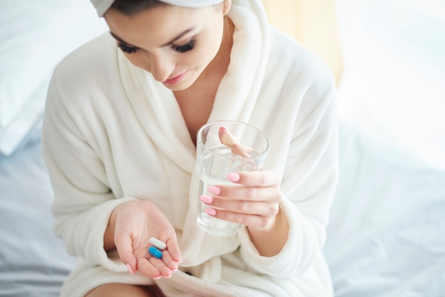 Mujer tomando pastillas para matar el dolor