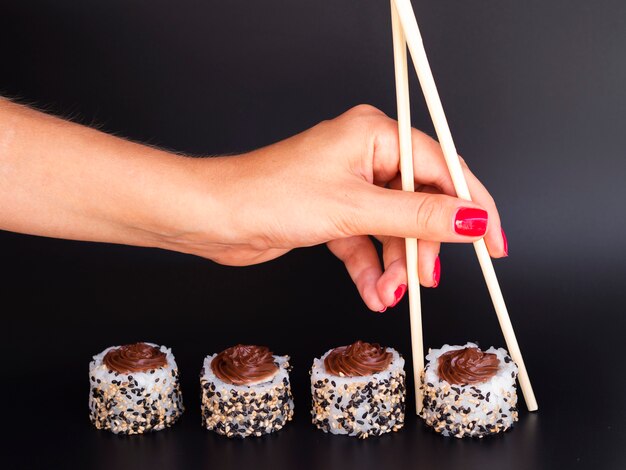 Mujer tomando un rollo de sushi