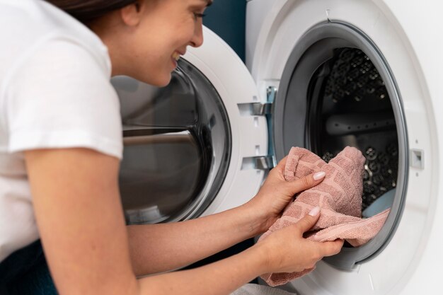 Mujer tomando ropa de la lavadora