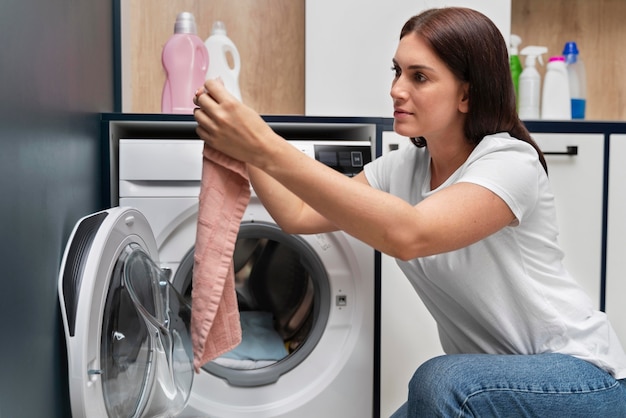 Foto gratuita mujer tomando ropa de la lavadora