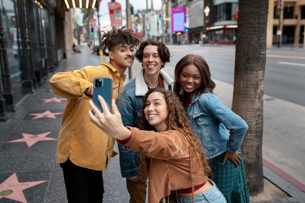 Mujer tomando selfie con amigos mientras está en la ciudad