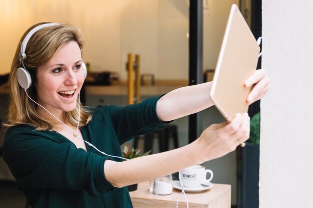 Mujer tomando selfie en café