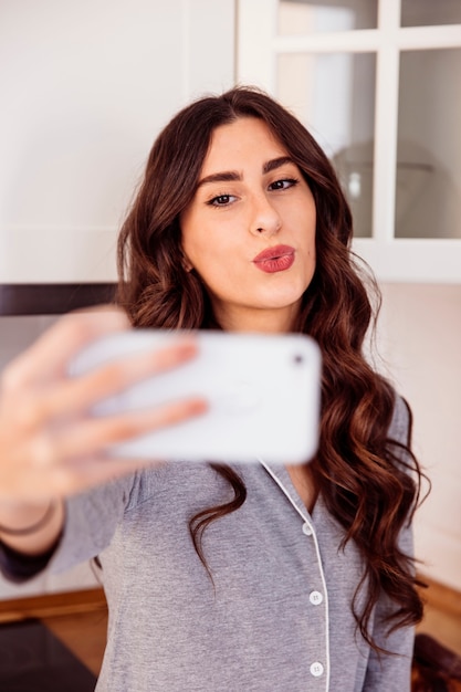 Mujer tomando selfie en cocina