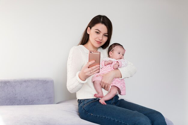 Mujer tomando selfie con hija