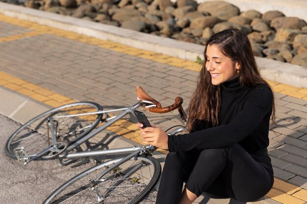 Mujer tomando un selfie junto a su bicicleta