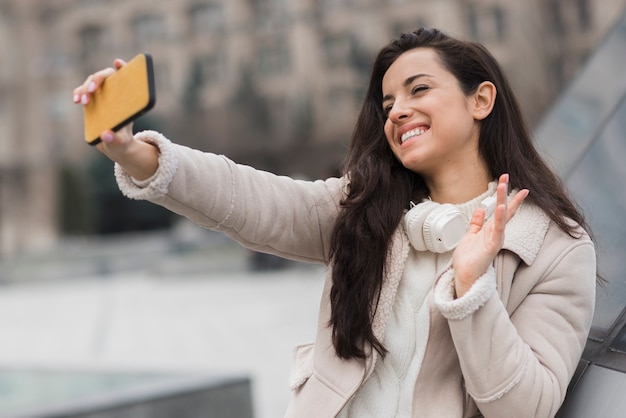 Foto gratuita mujer tomando selfie y saludando