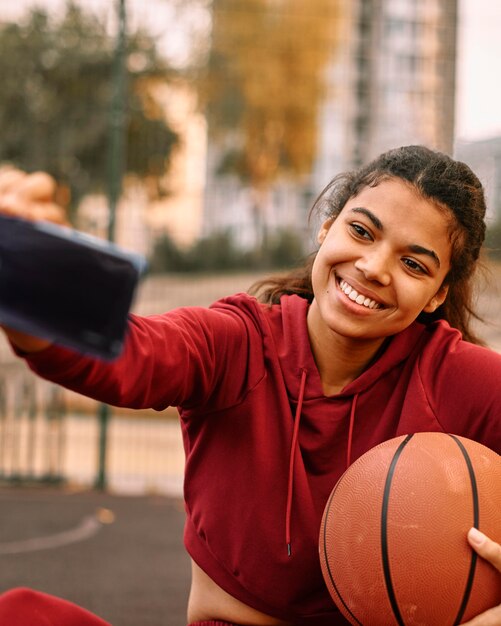 Mujer tomando un selfie con su baloncesto