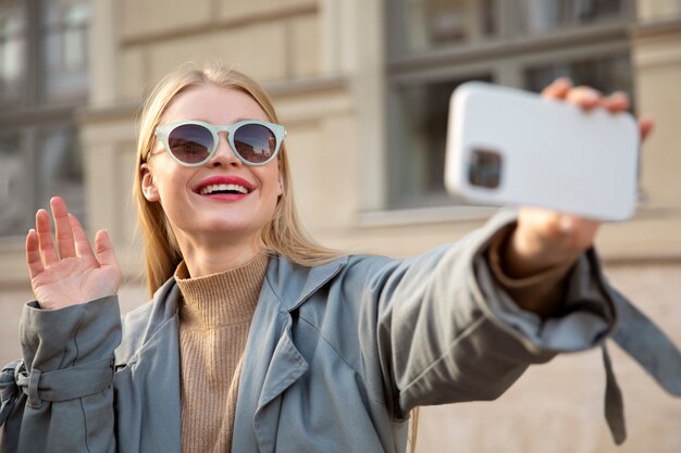 Mujer tomando selfie tiro medio