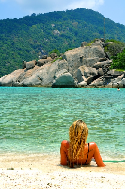 Mujer tomando el sol al lado del agua