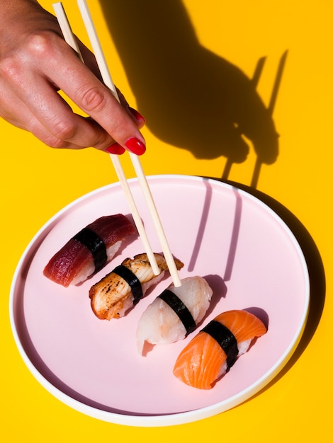 Mujer tomando un sushi forma un gran plato de rosas