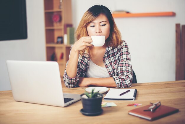 Mujer tomándose un café en el trabajo