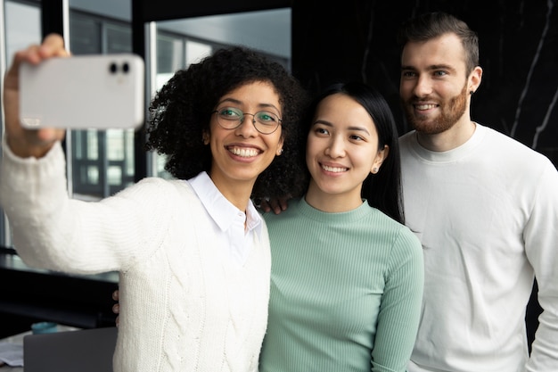 Foto gratuita mujer tomándose un selfie con sus colegas