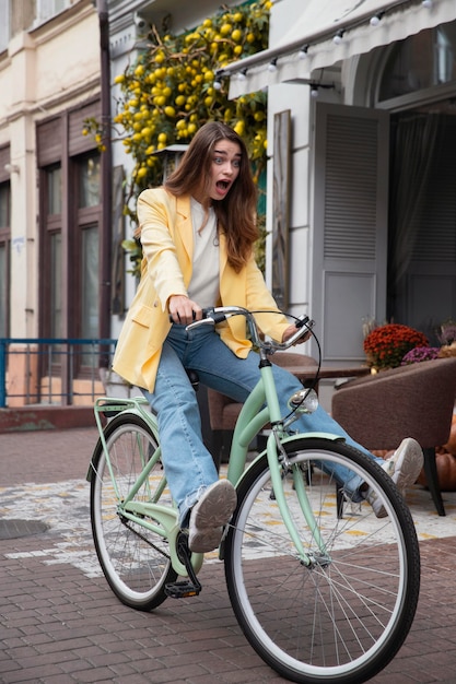 Mujer tonta montando su bicicleta al aire libre en la ciudad