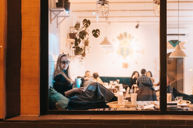 Mujer trabaja en un café en la noche