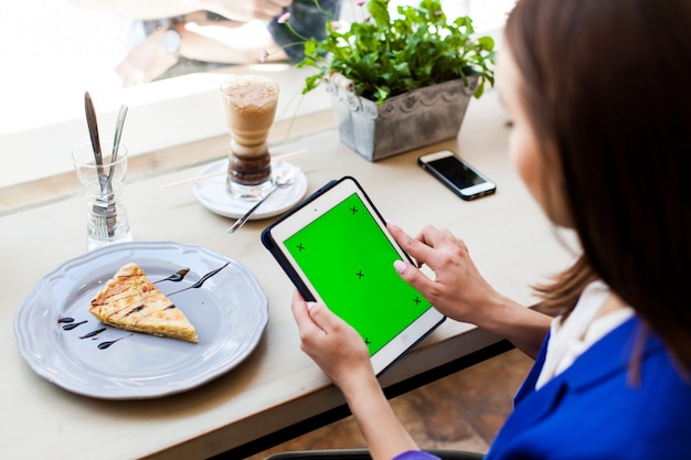 Foto gratuita mujer trabaja con una tableta en la mesa en un café