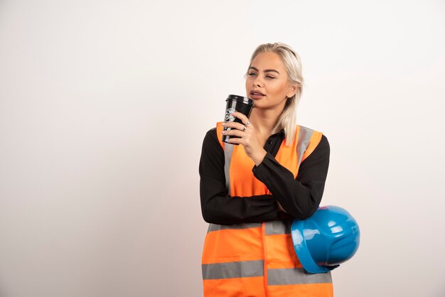 Mujer trabajadora industrial bebiendo una taza de café en su descanso. Foto de alta calidad