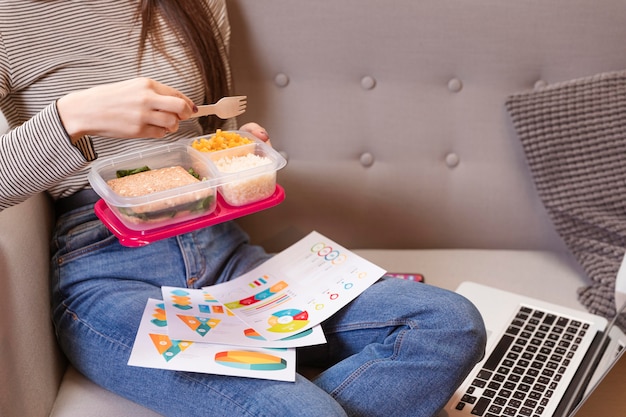 Foto gratuita mujer trabajando y comiendo en un sofá