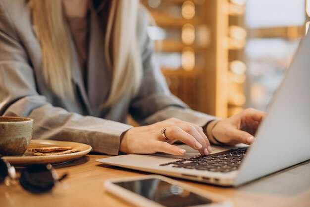 Mujer trabajando en una computadora en un café