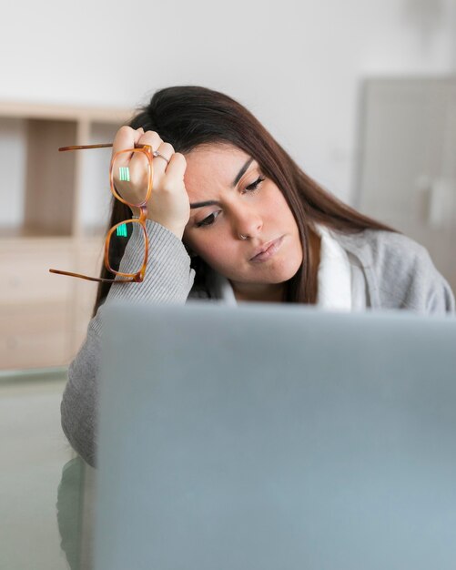 Mujer trabajando en la computadora portátil y sosteniendo copas