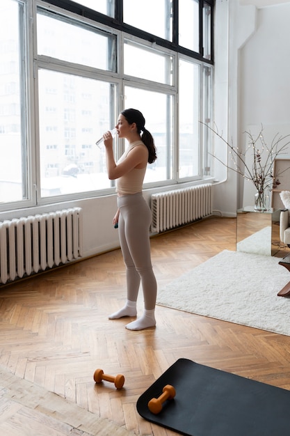 Foto gratuita mujer trabajando después de instructor de fitness en línea