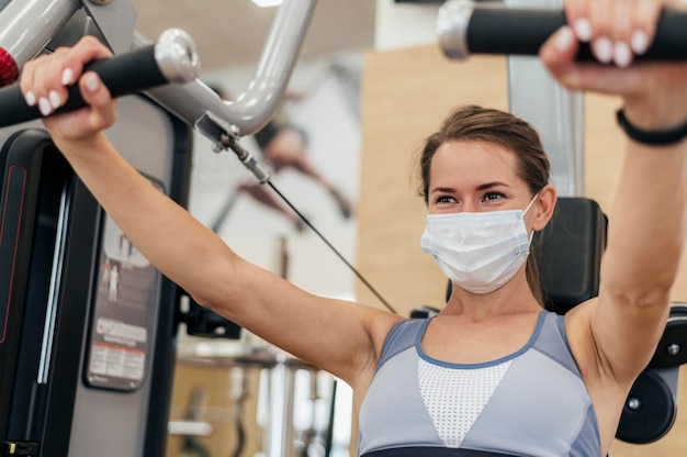 Mujer trabajando en el gimnasio durante la pandemia