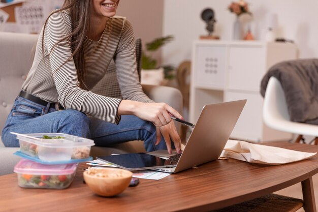 Mujer trabajando con loncheras junto a ella