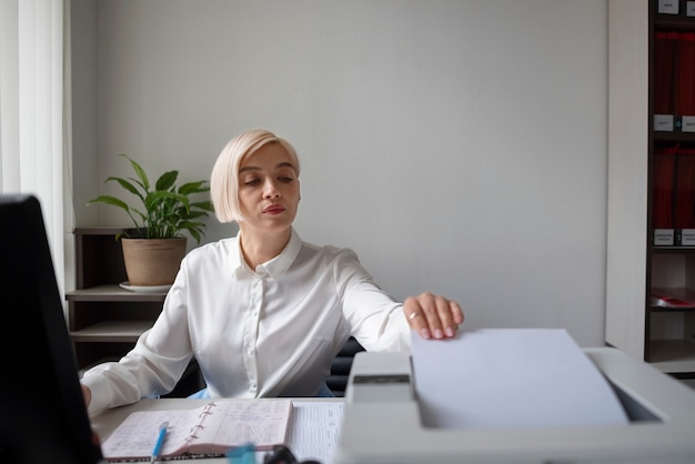 Mujer trabajando en la oficina y usando impresora