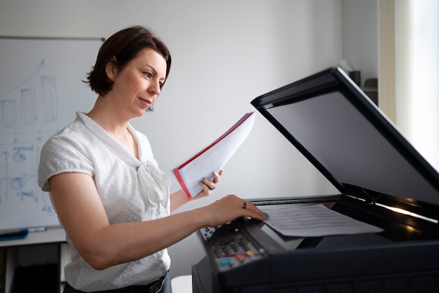 Mujer trabajando en la oficina y usando impresora