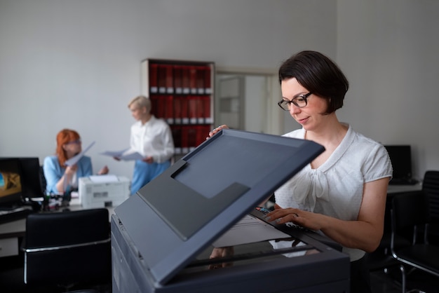 Mujer trabajando en la oficina y usando impresora