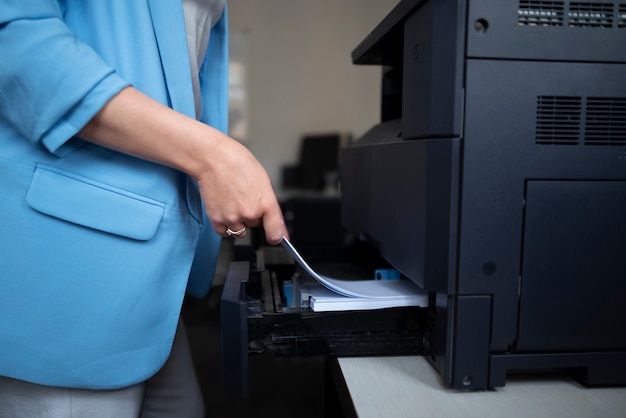 Mujer trabajando en la oficina y usando impresora