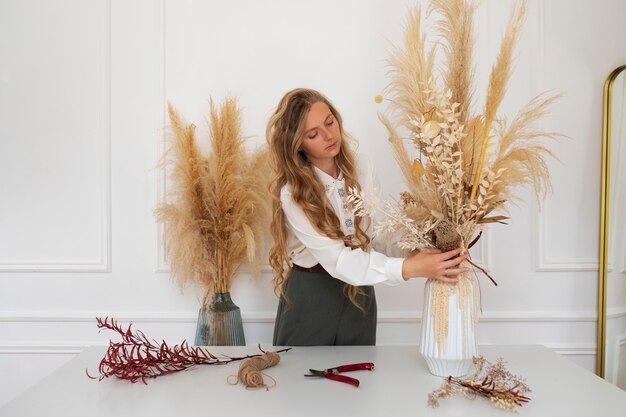 Mujer trabajando con plantas secas plano medio