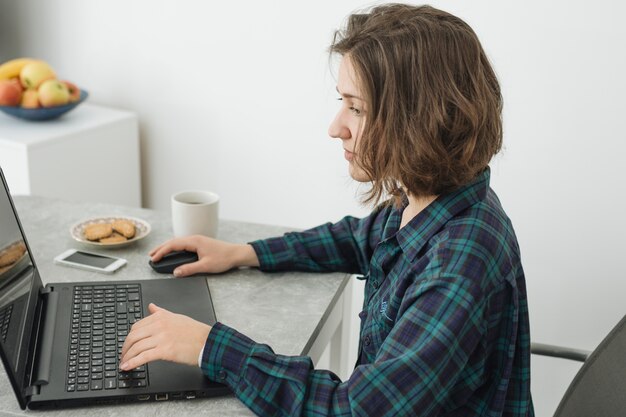 Mujer trabajando en portátil en casa