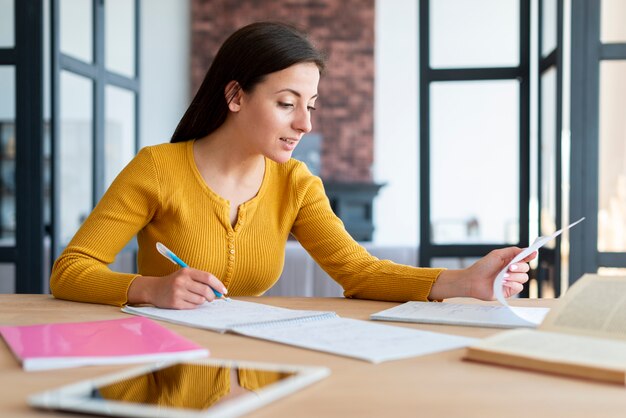 Mujer trabajando y revisando sus notas