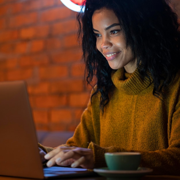 Mujer trabajando en su computadora portátil en una cafetería.