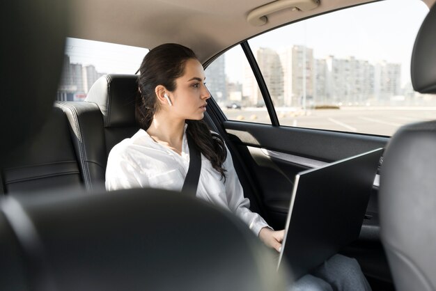 Mujer trabajando en su computadora portátil en el coche