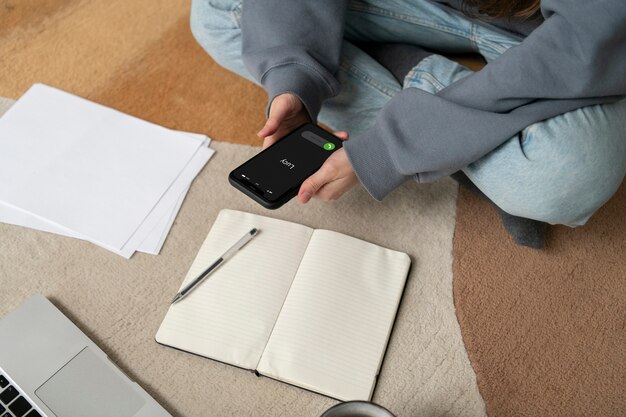 Mujer trabajando en el suelo desde casa con dispositivo