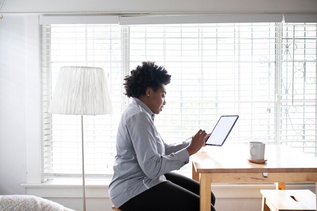 Mujer trabajando en una tableta digital en la nueva normalidad