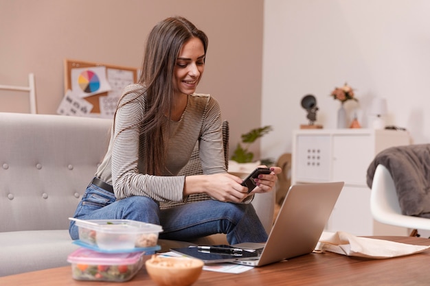 Mujer trabajando y teniendo loncheras junto a ella